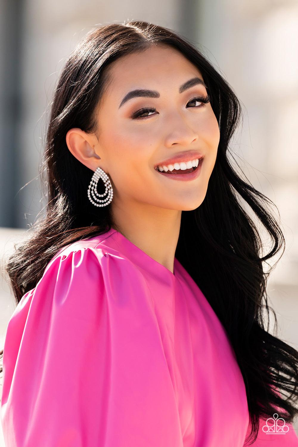 Paparazzi Accessories Take a POWER Stance - White Loops of glassy white rhinestones ripple out from the bottom of a stationary triangular fitting that is dotted in glittery white rhinestones, resulting in a timeless teardrop chandelier. Earring attaches t