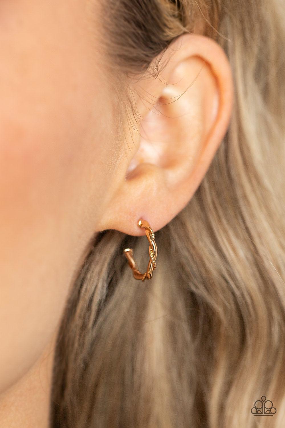 Paparazzi Accessories Irresistibly Intertwined - Gold A mismatched pair of glistening gold wires delicately twists into a classic hoop, creating a dainty peek of shimmer. Earring attaches to a standard post fitting. Hoop measures approximately 1/2" in dia
