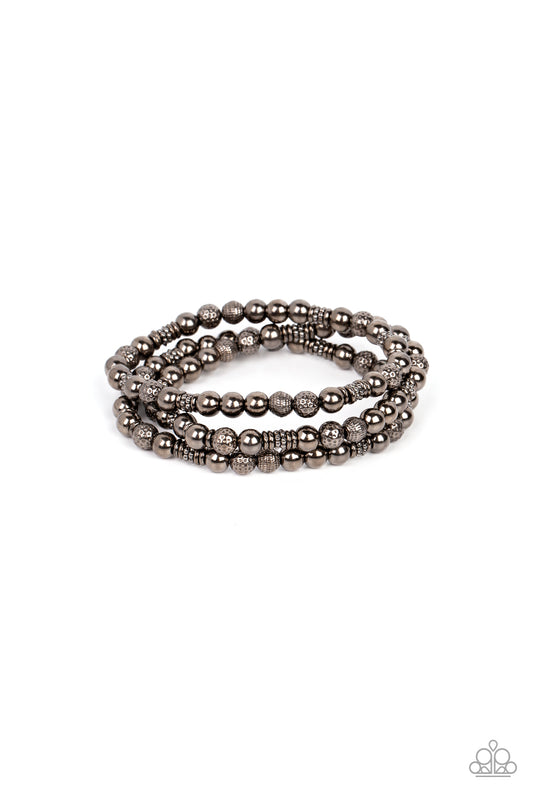 Paparazzi Accessories Boundless Boundaries - Black A gritty collection of smooth, studded, and textured gunmetal beads are threaded along stretchy bands around the wrist, creating dainty layers. Sold as one set of three bracelets. Jewelry