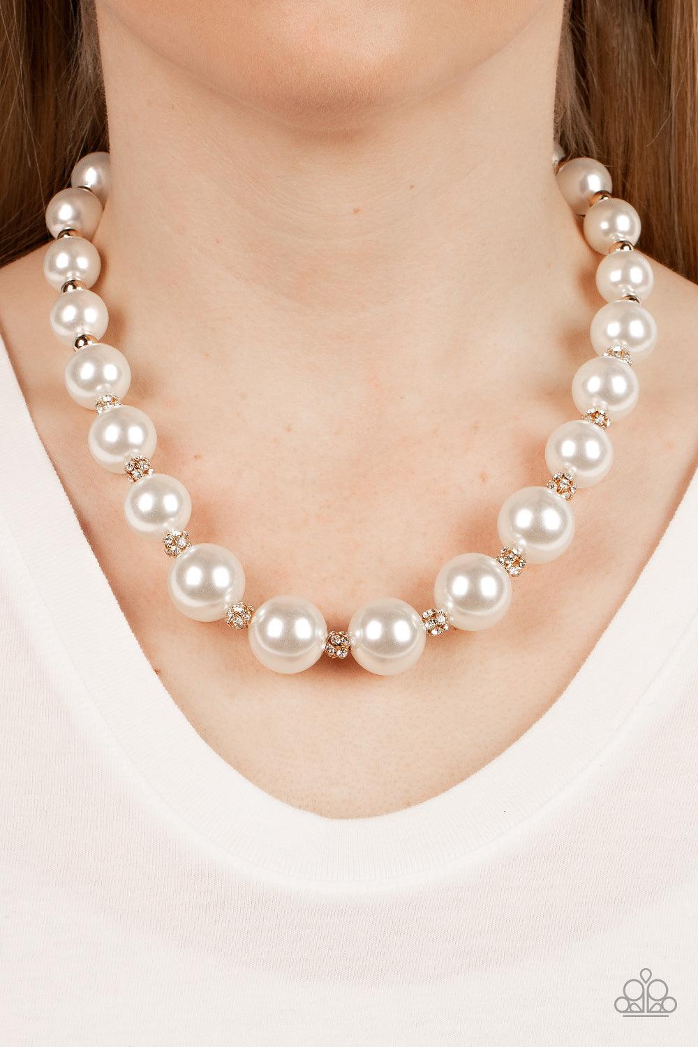 Paparazzi Accessories Sail Away with Me - Gold Gradually increasing in size, bubbly white pearls alternate with glistening gold beads and white rhinestone encrusted accents below the collar for a timeless finish. Features an adjustable clasp closure. Sold