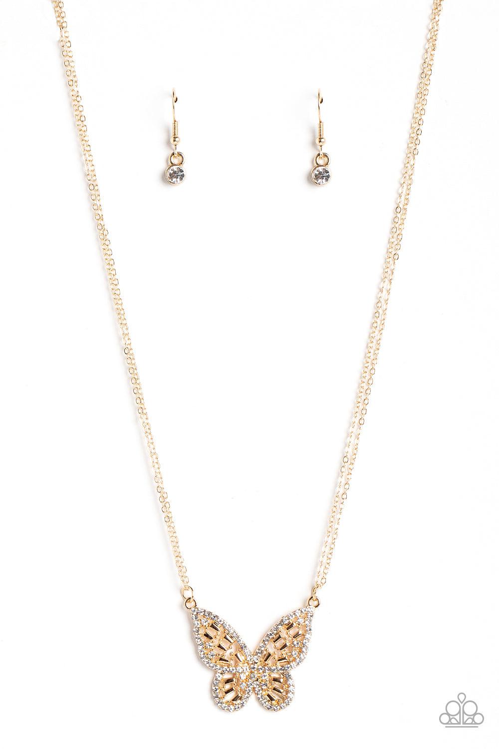 Paparazzi Accessories Baroque Butterfly - Gold Bordered in glassy white rhinestones, an airy gold butterfly is dotted in dainty white rhinestones and shiny gold emerald-like accents as it flutters from two chains below the collar for an enchanting fashion