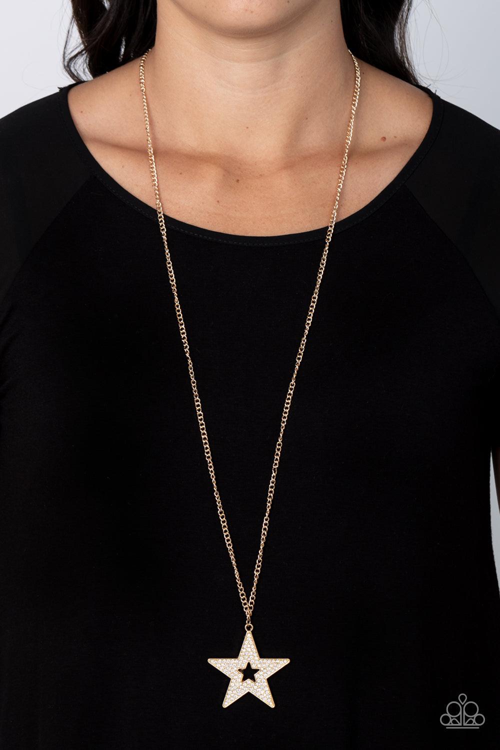 Paparazzi Accessories Superstar Stylist - Gold Blinding white rhinestones are encrusted across the front of an oversized gold star frame at the bottom of a lengthened gold chain, resulting in a stellar sparkle. Features an adjustable clasp closure. Sold a