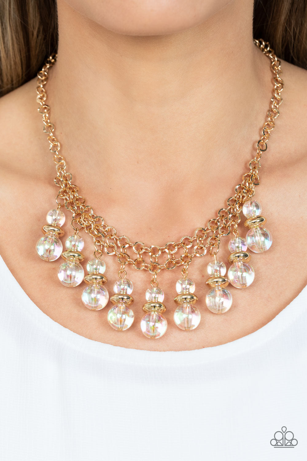 Paparazzi Accessories Deep Space Diva - Gold Featuring a stellar iridescence, pairs of glassy beads are separated by shiny gold discs, trickling below the collar in an effervescent fringe. Features an adjustable clasp closure. Due to its prismatic palette