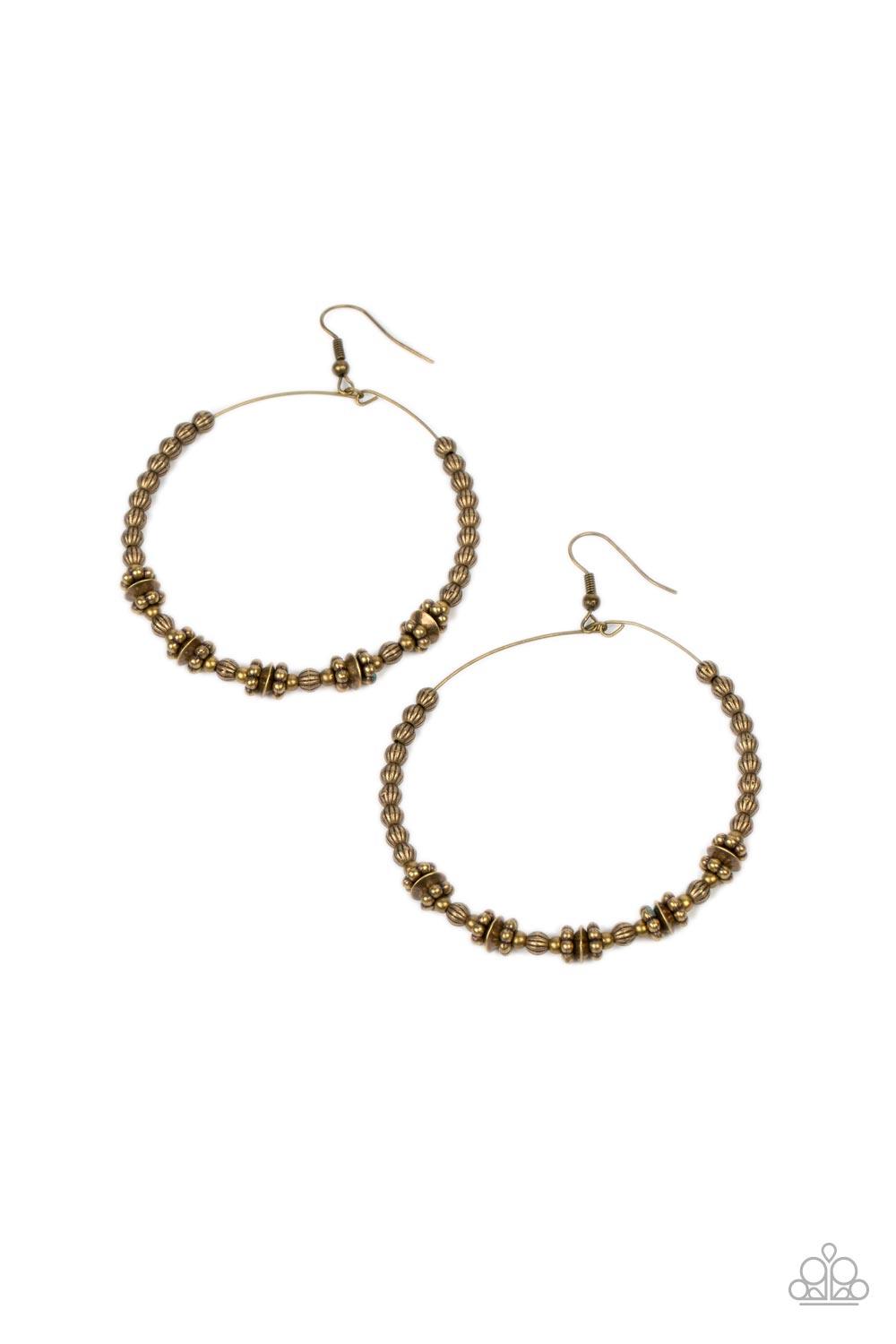 Paparazzi Accessories Simple Synchrony - Brass A dainty collection of ornate brass beads, studded brass rings, and brass discs are threaded along a dainty brass wire, resulting in a rustic hoop. Earring attaches to a standard fishhook fitting. Sold as one