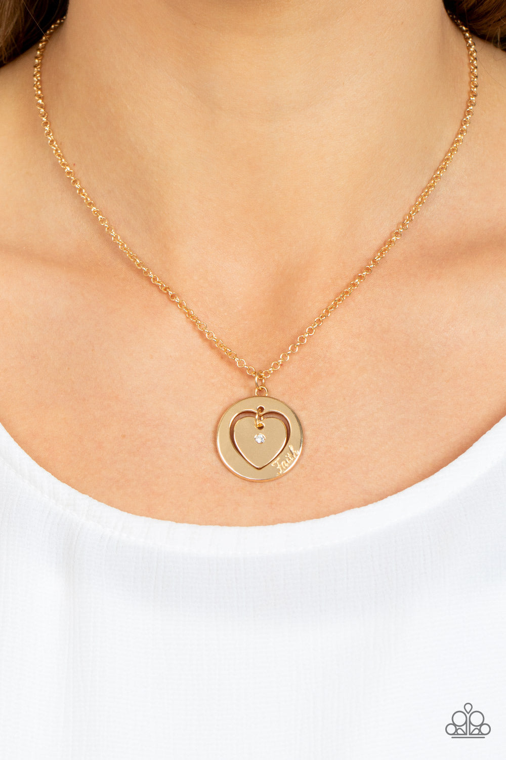 Paparazzi Accessories Heart Full of Faith - Gold Dotted with a dainty white rhinestone, a gold heart charm swings freely inside of a heart-cutout gold frame. Stamped in the word, "Faith," the inspirational pendant falls just below the collar for a sentime