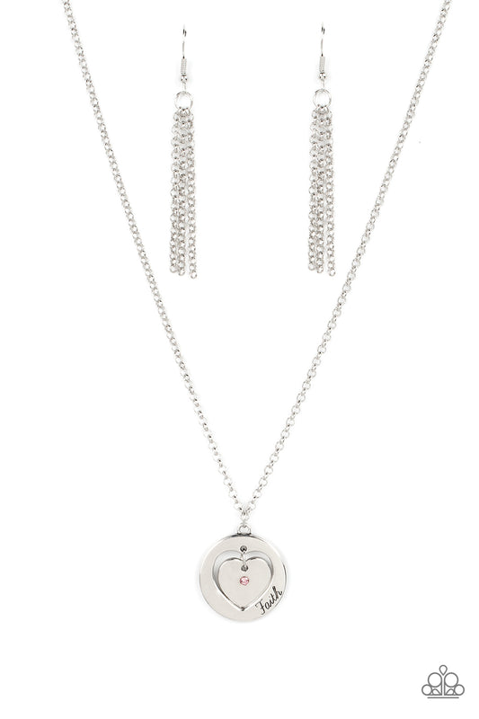 Paparazzi Accessories Heart Full of Faith - Pink Dotted with a dainty pink rhinestone, a silver heart charm swings freely inside of a heart-cutout silver frame. Stamped in the word, "Faith," the inspirational pendant falls just below the collar for a sent
