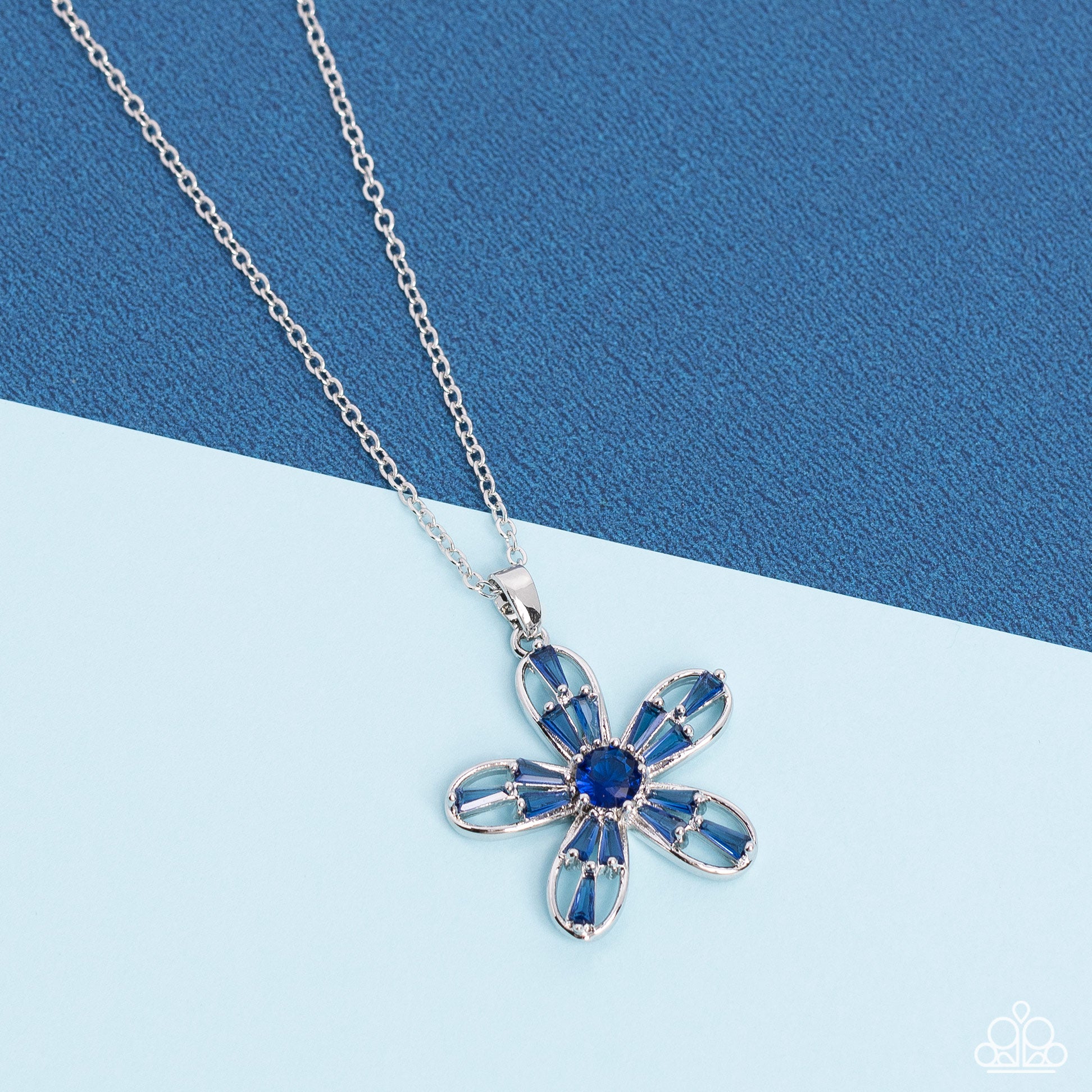 Paparazzi Accessories Botanical Ballad - Blue Emerald cut Skydiver rhinestones are scattered across the front of airy silver petals that bloom from a Skydiver rhinestone center, resulting in a sparkly floral pendant below the collar. Features an adjustabl