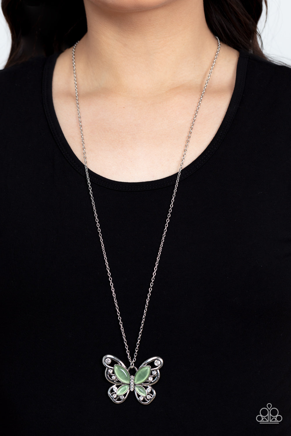 Paparazzi Accessories Wings Of Whimsy - Green Swirls of silver filigree curl into the shape of a butterfly, creating a whimsical pendant that swings from the bottom of a long silver chain. Glassy green cat's eye stones layer atop the silver filigree, addi