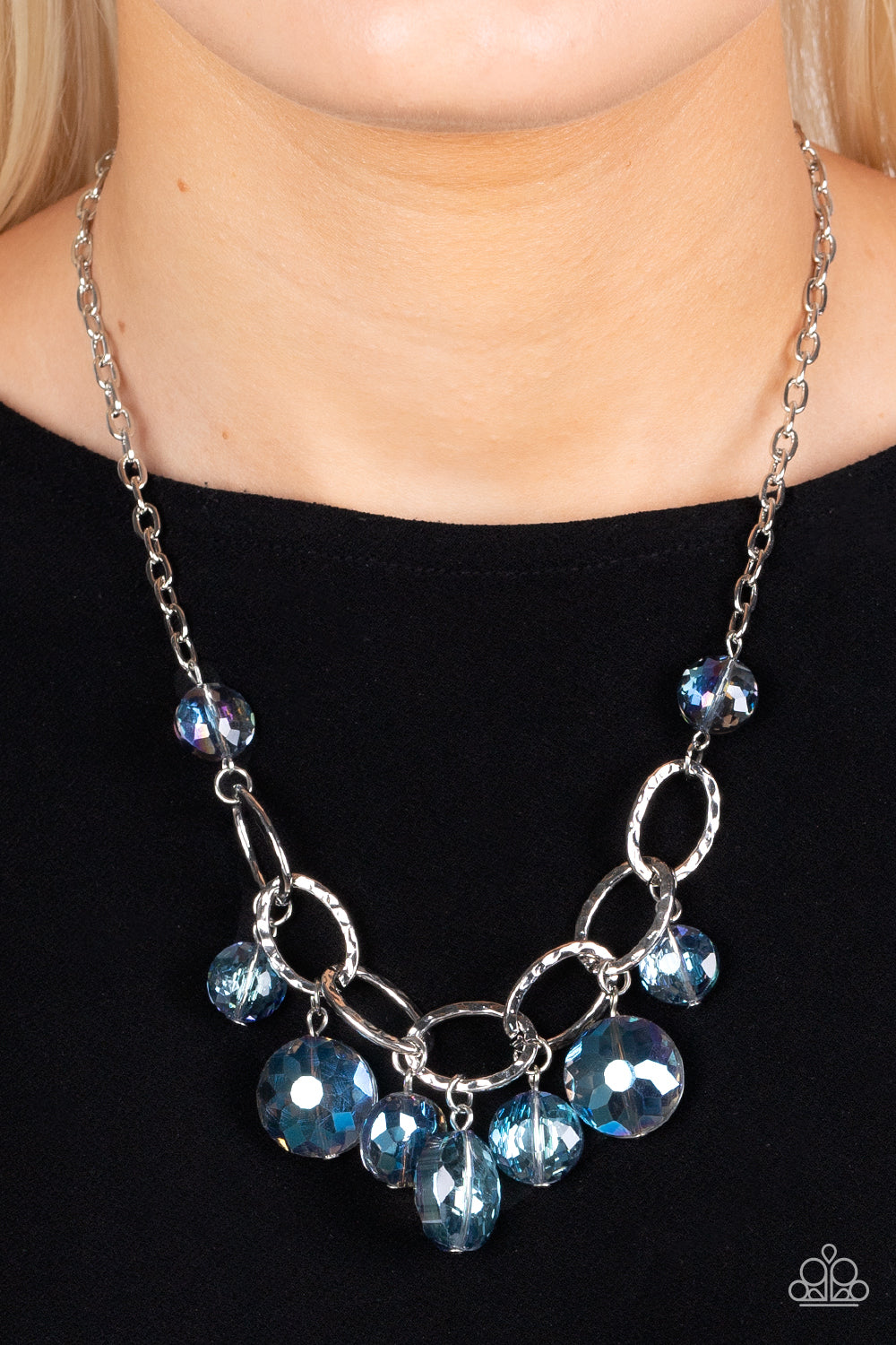 Paparazzi Accessories Rhinestone River - Blue A collection of round, glassy blue beads in varying sizes swirl around shiny silver oval links hammered in texture. The beveled shape and faceted surfaces of the beads are brushed in a subtle reflective glaze,