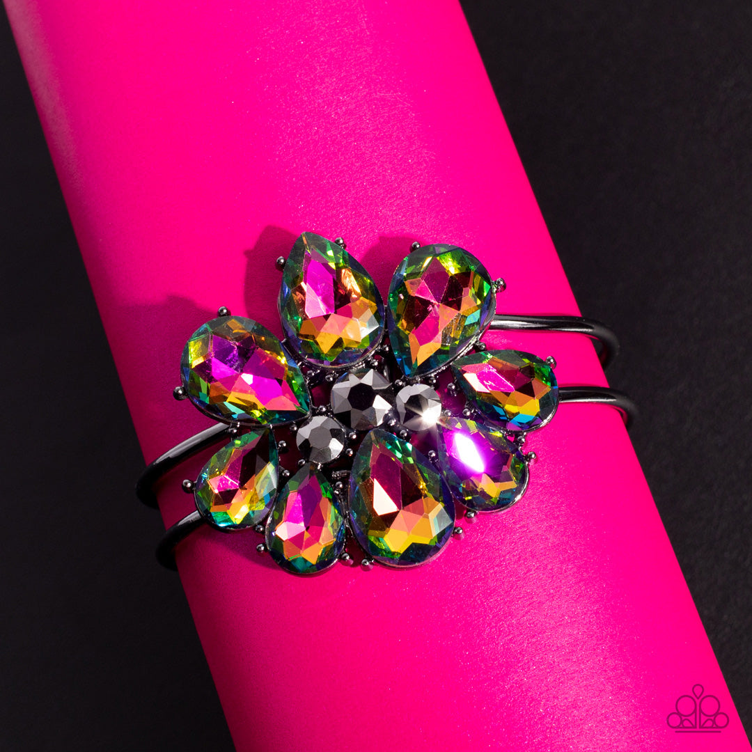 Paparazzi Accessories DAUNTLESS is More - Multi A dazzling collection of oil spill teardrop gems dramatically fan out around three round pieces of hematite, creating an explosion of sparkle. The exaggerated gems circle into a floral centerpiece that sits