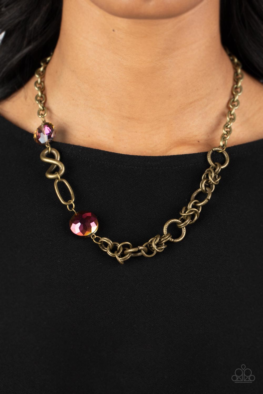 Paparazzi Accessories Celestially Celtic - Brass Thick links of brass twist into Celtic knot-like details, linking together with textured brass hoops along the collar. A pair of faceted, saucer-shaped crystal beads, dipped in a reflective oil spill coatin