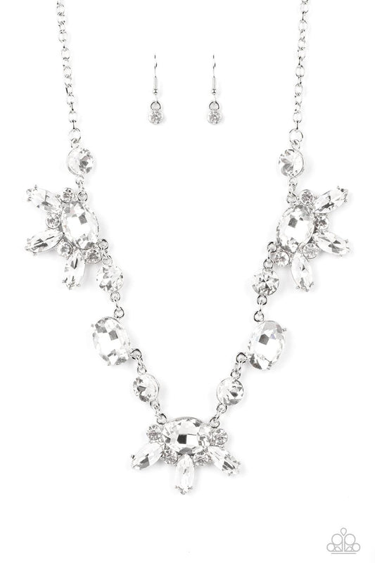 Paparazzi Accessories GLOW-trotting Twinkle - White Brilliant white rhinestones in round, oval, and marquise cuts, create an abstract pattern as they fall along the neckline. The faceted surfaces of each gem catch and reflect light from every angle, resul