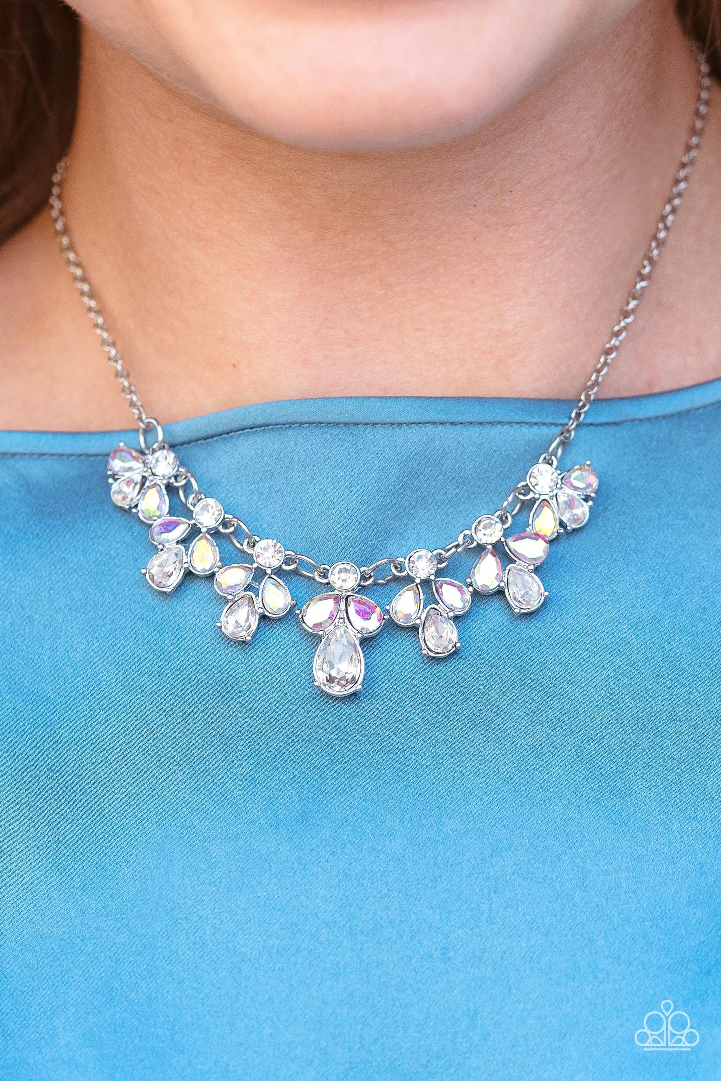 Paparazzi Accessories See in a New STARLIGHT - White Dainty white reflective gems, followed by a trio of iridescent and reflective teardrop gems vertically blaze down the collar, creating a starry shimmer. Due to its prismatic palette, color may vary. Fea