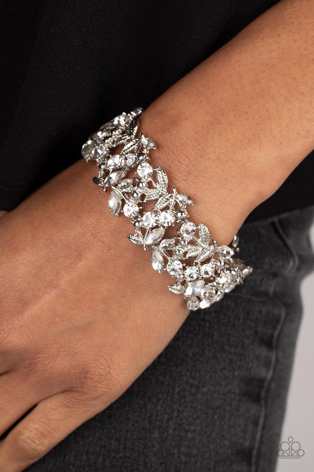 Paparazzi Accessories Feathered Finesse -White Round and marquise-cut white gems intertwine around polished silver studs and ornate feather-like details in a glitzy pattern. The textured, glittery display is threaded along elastic stretchy bands for a whi