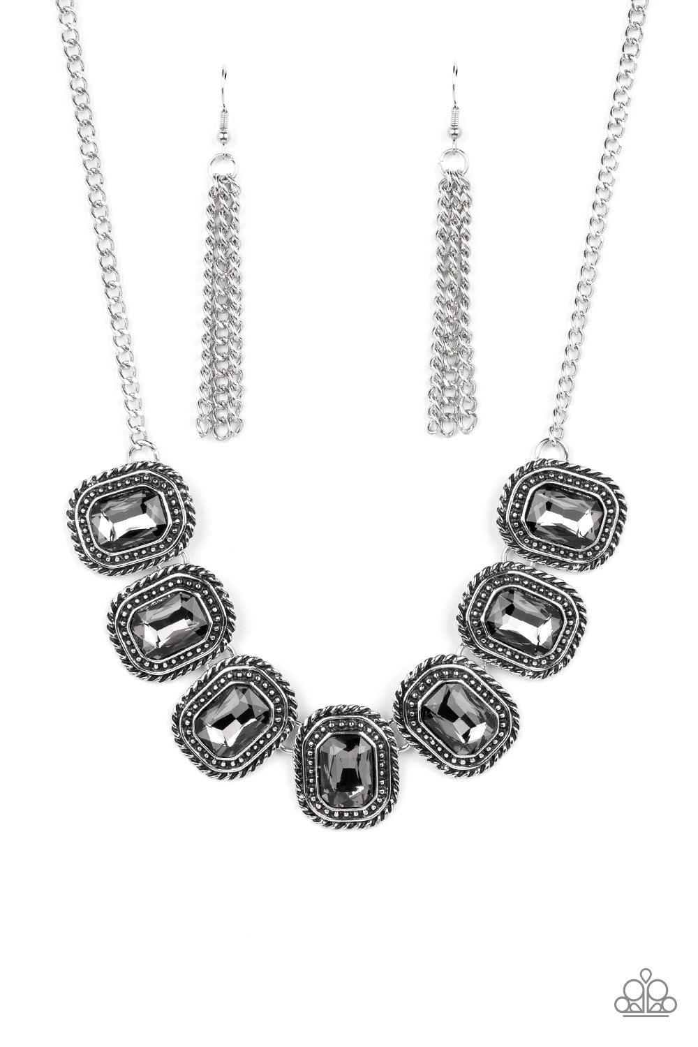 Paparazzi Accessories Iced Iron - Silver Pressed into silver, chain-like frames, radiant-cut hematite rhinestones smolder below the collar in a jaw-dropping finish. Each frame is embellished with twisted texture and subtle silver studs, bringing a gritty