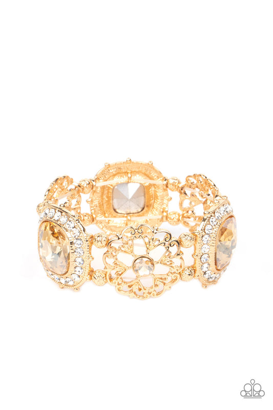 Paparazzi Accessories Gilded Gallery - Gold Oversized faceted golden gems in dramatically rounded square cuts are wrapped in borders of classic white rhinestones, emitting a breathtaking sheen. Floral-inspired frames, dotted with solitaire golden rhinesto