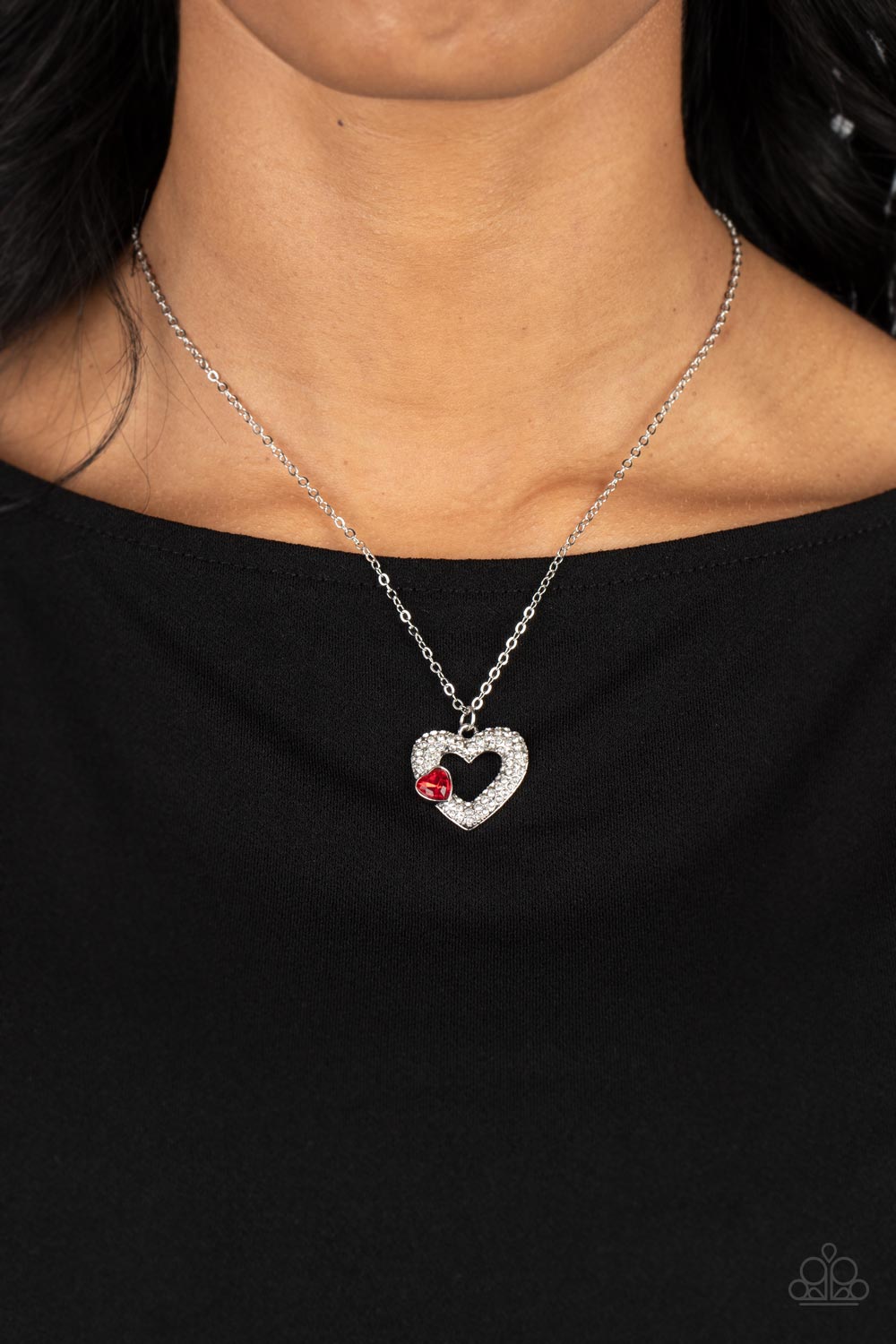 Paparazzi Accessories Bedazzled Bliss - Red A luxurious airy silver heart lush with glassy white rhinestones swings from a classic silver chain. A faceted heart gem brushed in a red shimmer graces one side of the larger bedazzled heart for a romantic fini