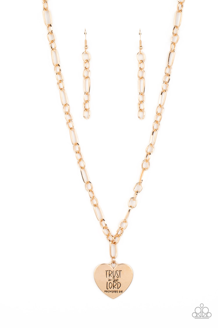 Paparazzi Accessories Perennial Proverbs - Gold Dangling from a gold figaro chain, a charming heart pendant swings. Stamped upon the shiny surface, the phrase "Trust in the Lord" with the bible reference listed below it "Proverbs 3:5" are listed in differ