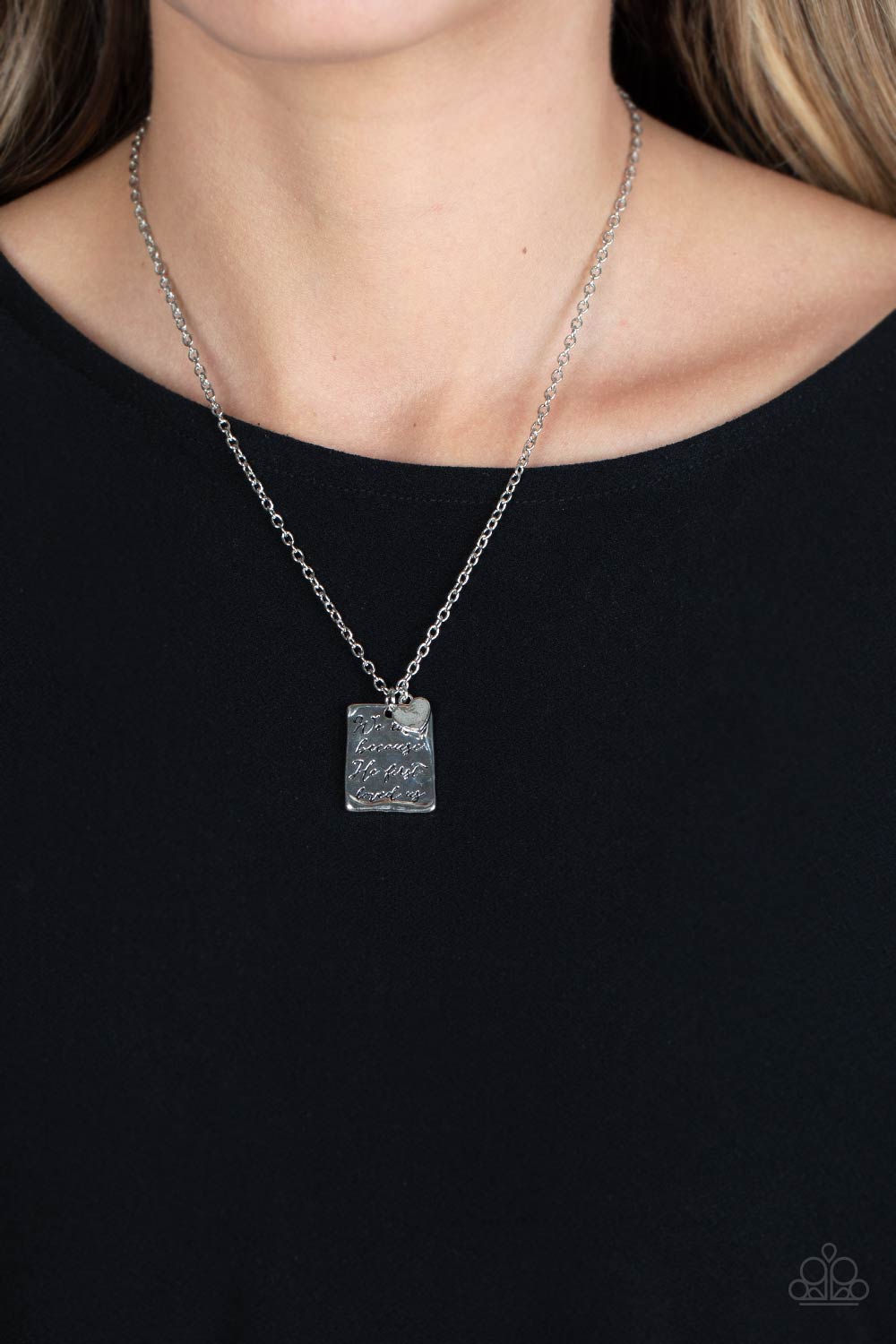 Paparazzi Accessories Divine Devotion - Silver Dangling below a delicate silver chain, a hammered rectangular plate swings for some light-catching movement. The religious phrase "We love because He first loved us" is prominently stamped in the center of t