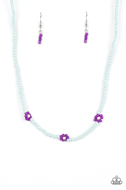 Paparazzi Accessories Bewitching Beading - Purple Strung along the entirety of an invisible wire, light blue seed beads coalesce around the collar. The row of blue seed beads are haphazardly interrupted by blooming purple seed bead flowers, with baby pink