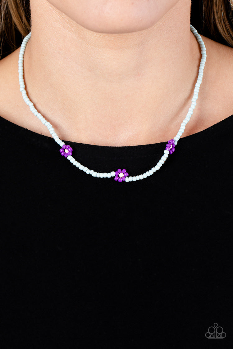 Paparazzi Accessories Bewitching Beading - Purple Strung along the entirety of an invisible wire, light blue seed beads coalesce around the collar. The row of blue seed beads are haphazardly interrupted by blooming purple seed bead flowers, with baby pink