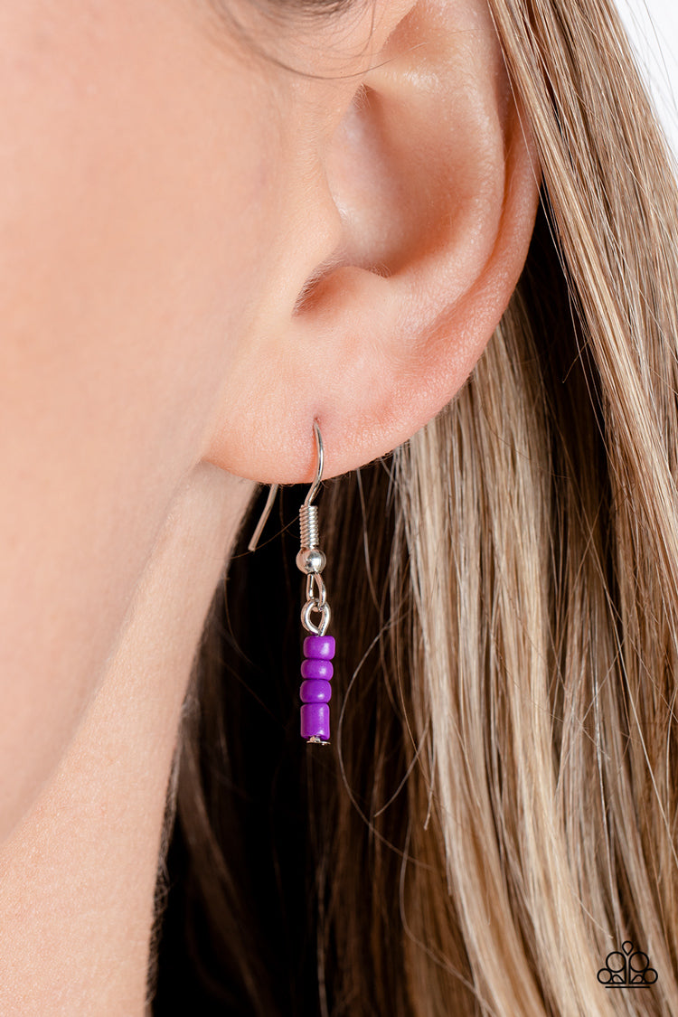 Paparazzi Accessories Bewitching Beading - Purple Strung along the entirety of an invisible wire, light blue seed beads coalesce around the collar. The row of blue seed beads are haphazardly interrupted by blooming purple seed bead flowers, with baby pink