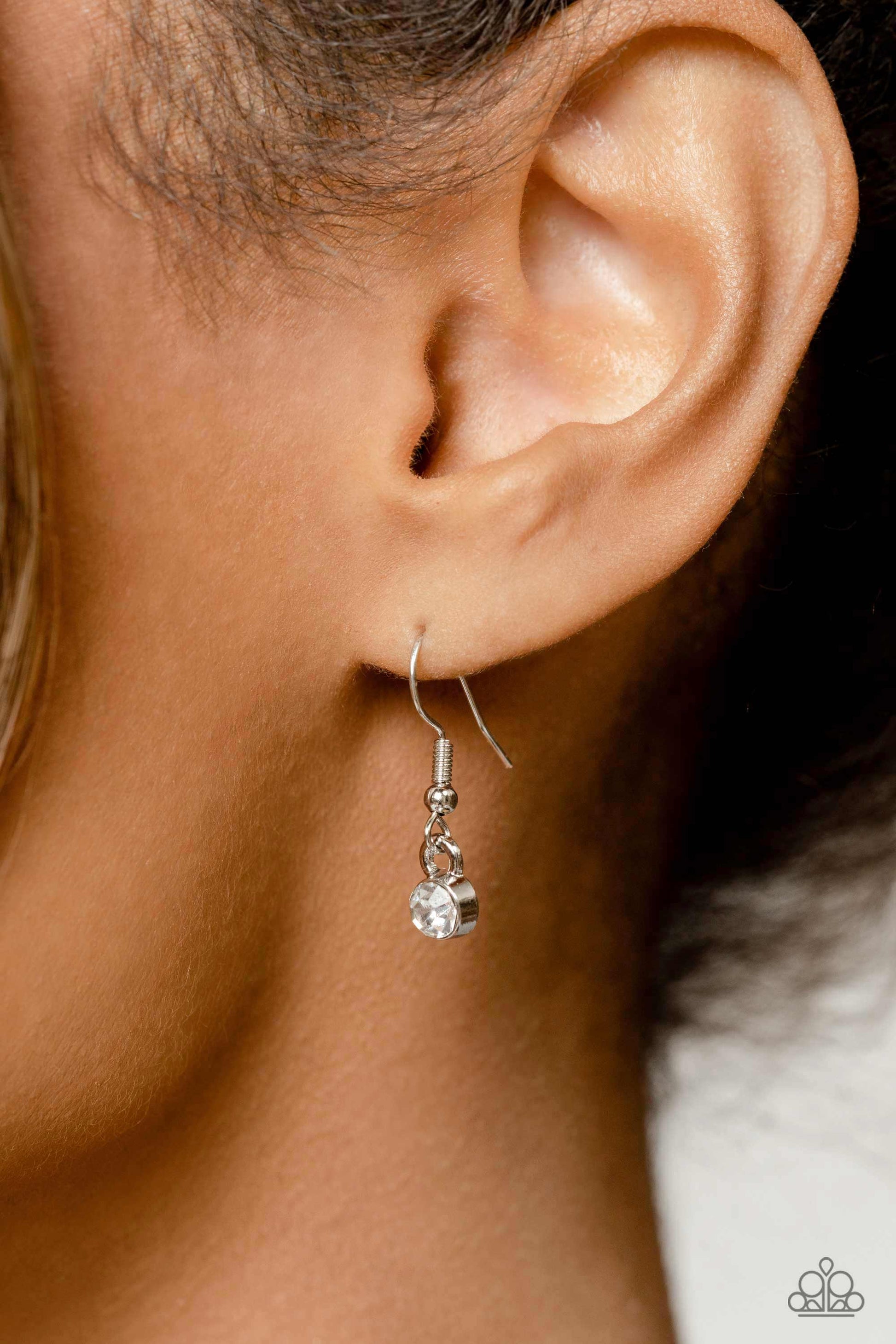 Paparazzi Accessories TWINKLE of an Eye - White Adorned with a dainty silver chain, a twinkling collection of white, reflective teardrops, rhinestones and marquise-cut gems glitter down the chest. Hanging at the bottom of the glittery collection, an overs