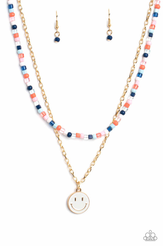 Paparazzi Accessories High School Reunion - Blue Gliding from a dainty, gold chain, a smiley face pendant stands out against a white backdrop. Completing the charismatic ensemble, a collection of seed beads in shades of Spun Sugar, baby pink, navy blue, w