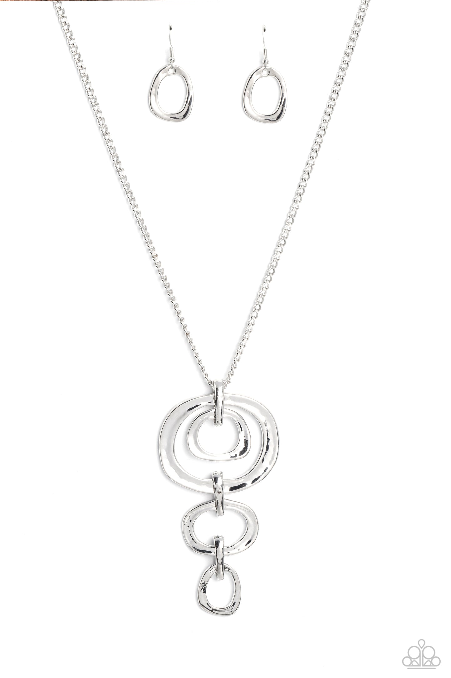 Paparazzi Accessories Tranquil Trickle - Silver Trickling down the chest from an elongated silver chain, a mismatched assortment of hammered silver abstract rings glistens in this monochromatic masterpiece. Features an adjustable clasp closure. Sold as on