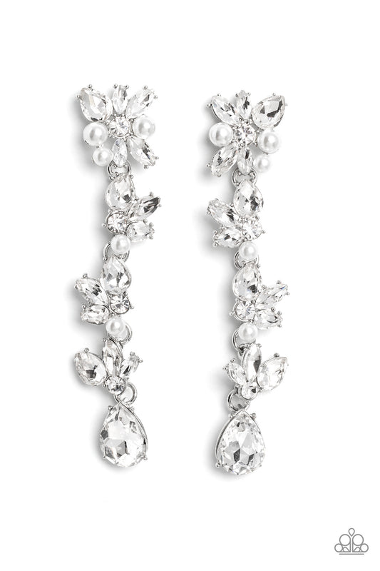 Paparazzi Accessories LIGHT at the Opera - White Radiant clusters of white reflective teardrop, marquise-cut and round gems combine with classic white pearls to create an explosion of glitz that extends down the ear. Hanging from the bottom of the light-r
