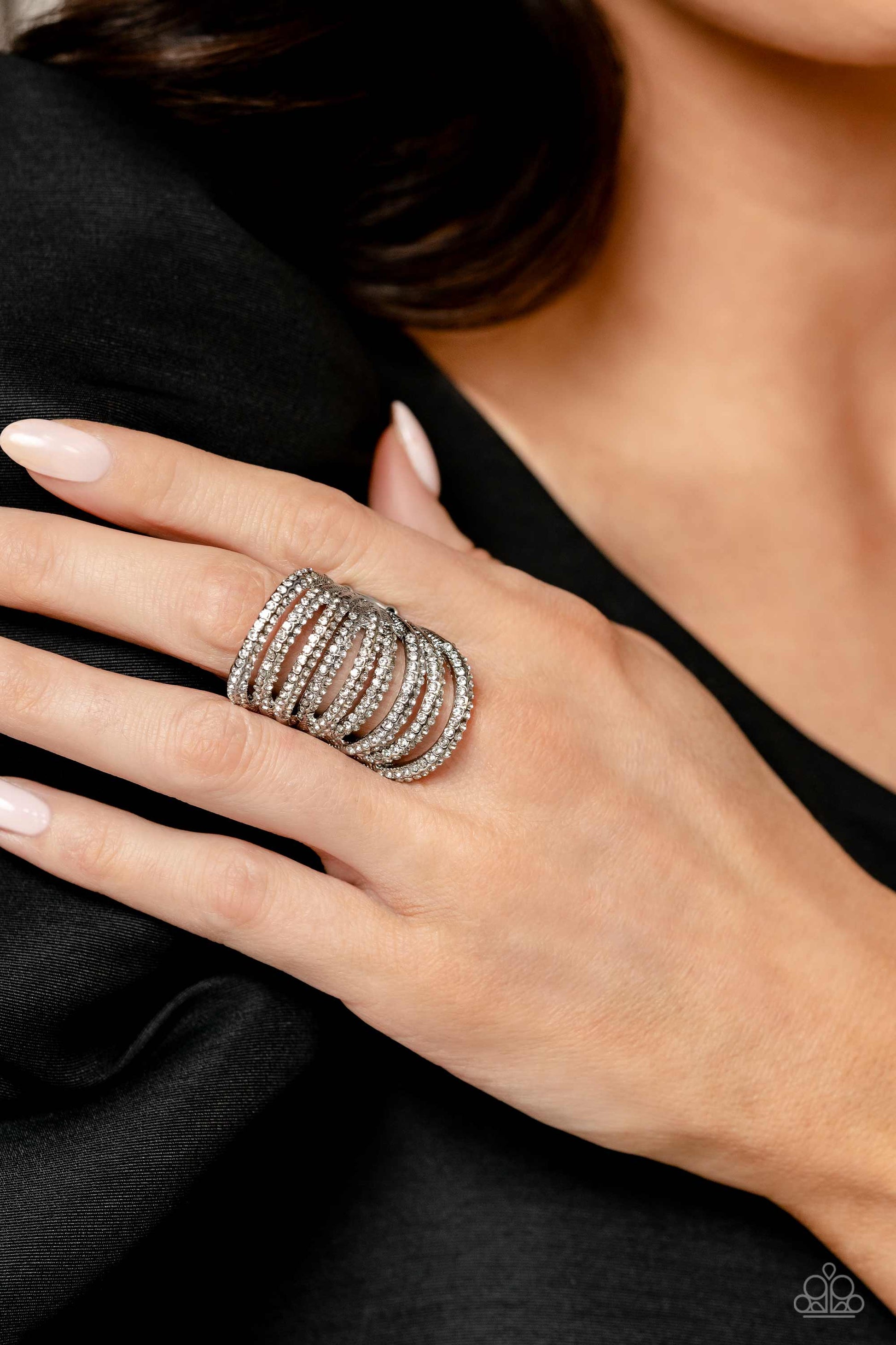 Paparazzi Accessories Rippling Rarity - White An elongated silver frame, lined with dainty white rhinestones, creates the illusion of endless sparkle as it stacks up the finger. Encrusted in two rows across each silver band as it arcs across the finger, t