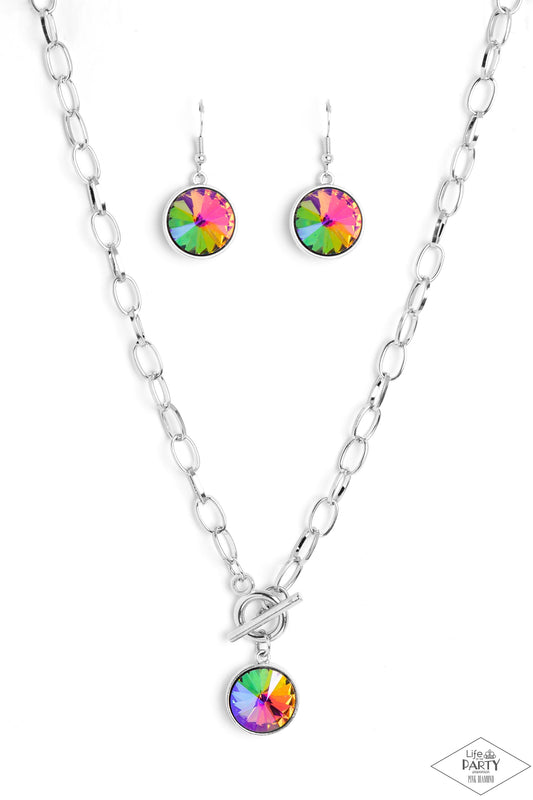 Paparazzi Accessories She Sparkles On - Multi A dramatic gem with a UV shimmer swings from the bottom of a shiny silver chain, creating a blinding pendant below the collar. Features a toggle closure. Due to its prismatic palette, color may vary. Sold as o