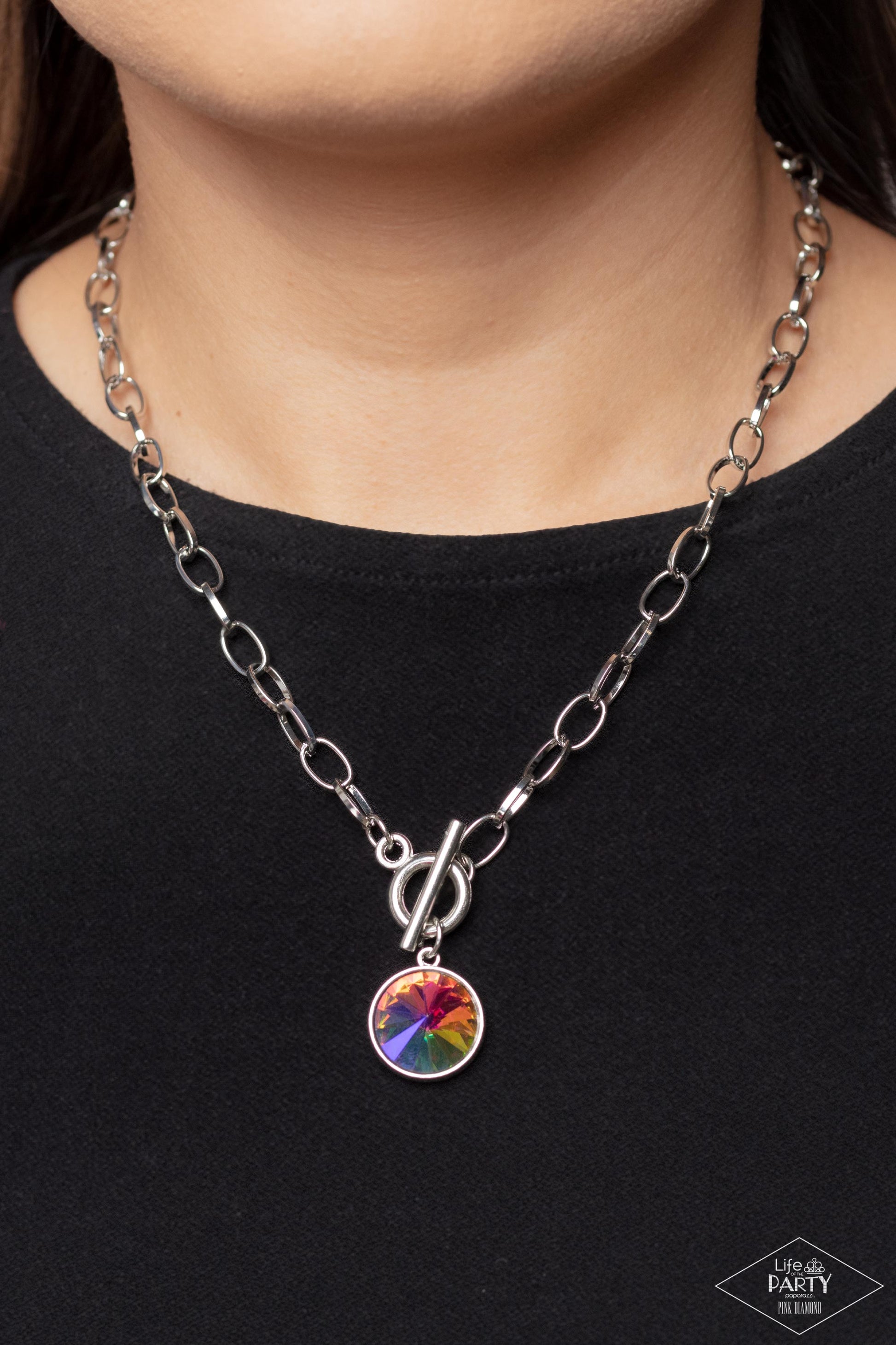 Paparazzi Accessories She Sparkles On - Multi A dramatic gem with a UV shimmer swings from the bottom of a shiny silver chain, creating a blinding pendant below the collar. Features a toggle closure. Due to its prismatic palette, color may vary. Sold as o