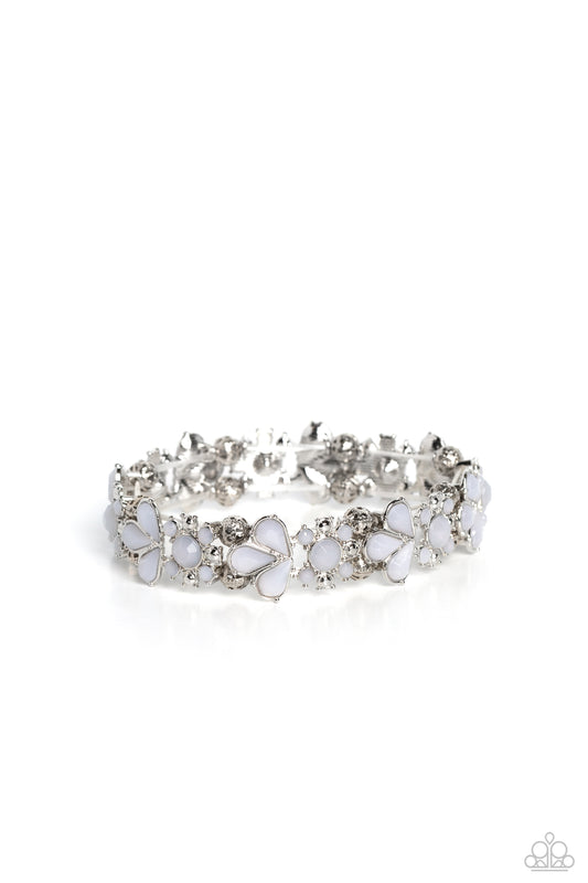 Paparazzi Accessories Teasing Torrent - White A flourishing opaque collection of white round and teardrop beads coalesce into abstract floral-inspired frames. Separating each floral frame, airy, silver-studded beads are infused along elastic stretchy band
