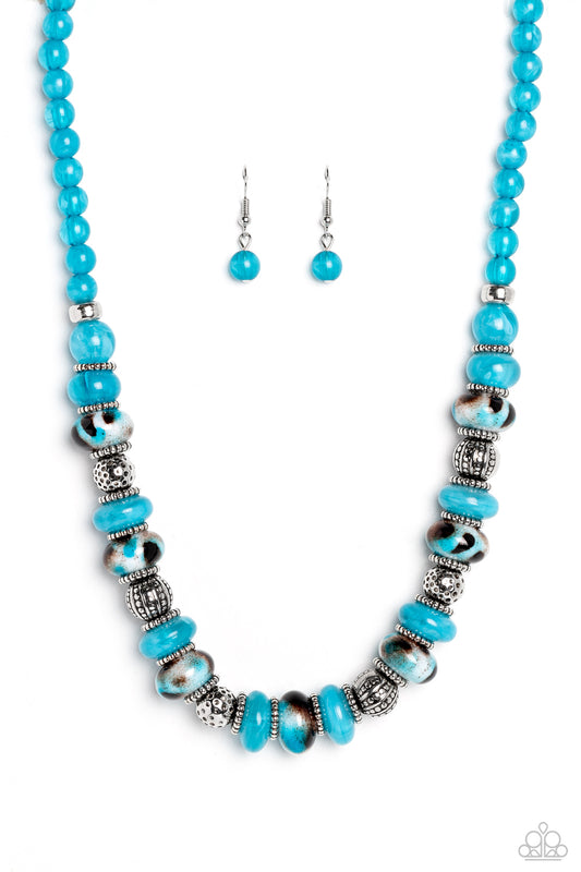 Paparazzi Accessories Warped Whimsicality - Blue An earthy collection of dotted silver beads, rounded milky turquoise beads, studded silver rings, turquoise-spotted ceramic-like beads and textured silver beads are threaded along an invisible wire below th