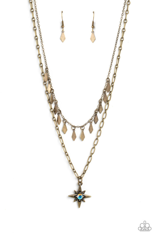 Paparazzi Accessories The Second Star To The LIGHT - Brass A three-dimensional brass star, dotted with a single iridescent rhinestone glides on a paperclip chain down the neckline for an out of-this-world-vibe. Flat and flared brass frames dance above the