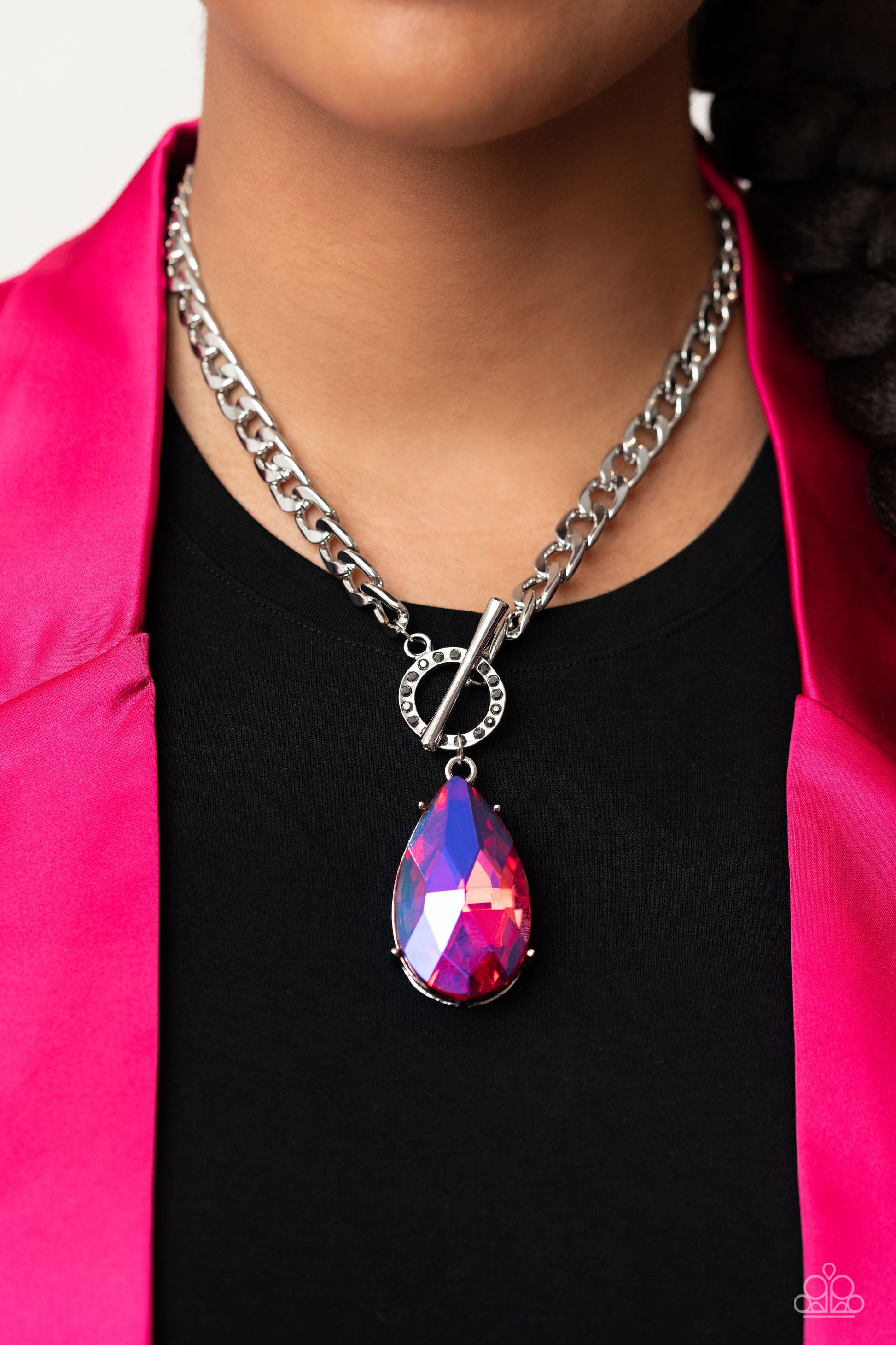Paparazzi Accessories Edgy Exaggeration - Pink Featuring an elegant lariat closure, an oversized, faceted, stellar pink UV shimmery teardrop gem, encased in an elevated pronged silver frame cascades from the bottom of a silver curb chain in a whimsical fa