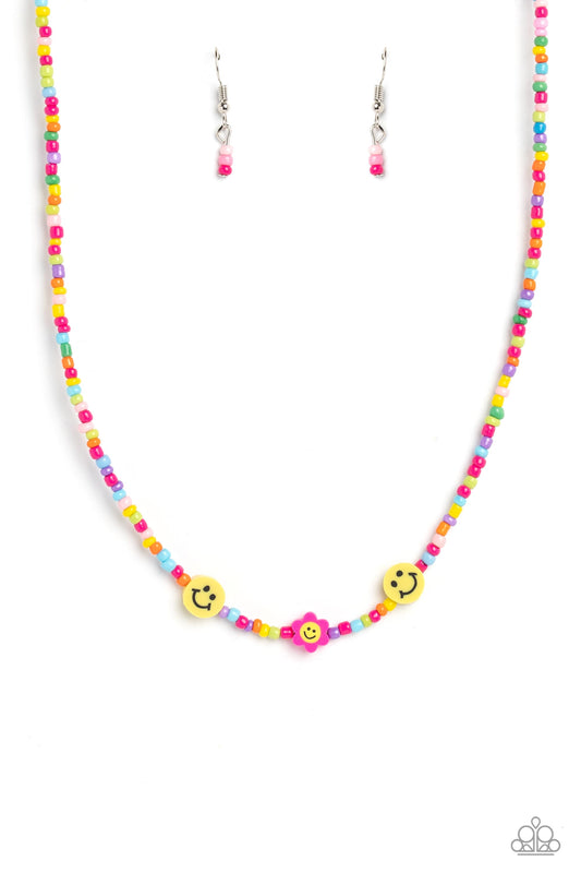 Paparazzi Accessories Flower Power Pageant - Pink Bright colorful seed beads are threaded along a wire, falling along the collar in a capricious pattern. Bringing additional charm to the design, yellow smiley face beads, and a pink flower with a yellow sm