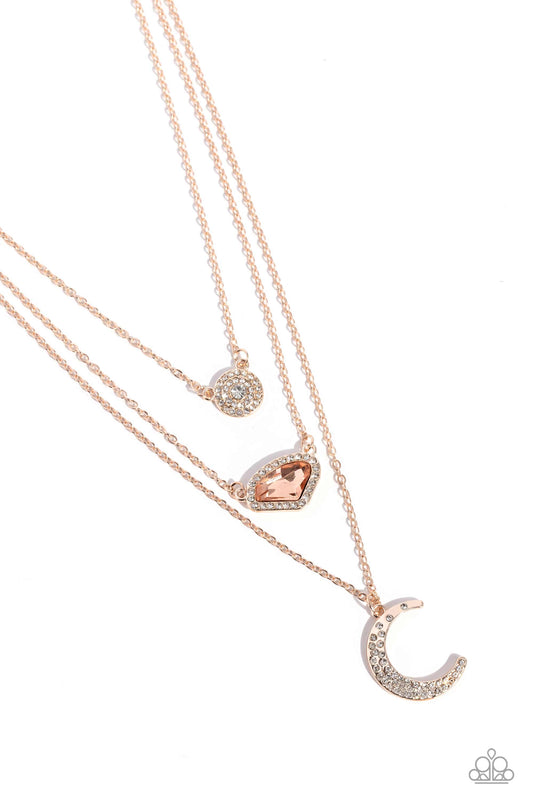 Paparazzi Accessories Lunar Lineup - Rose Gold Three shimmery rose gold chains, infused with three stellar pendants, layer across the chest in a celestial display. A dainty, white rhinestone-encrusted, rose gold pendant with a white center swings from the