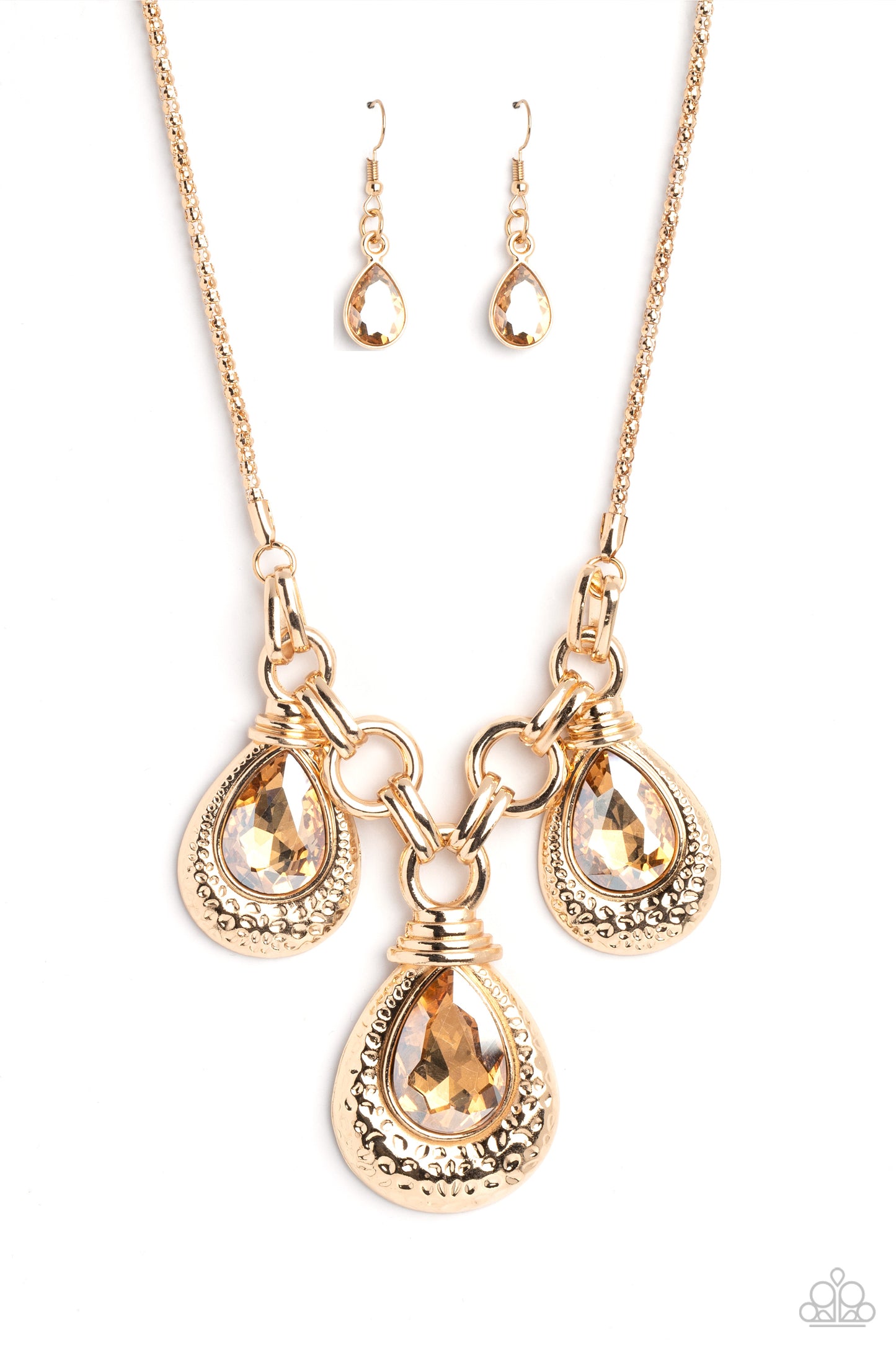 Paparazzi Accessories Built Beacon - Gold Oversized links of gold are artfully interlocked, laying the groundwork for a dynamic display of industrial grit. A trio of oversized champagne, faceted, teardrop gems drips from the chainlinks above, each set ins