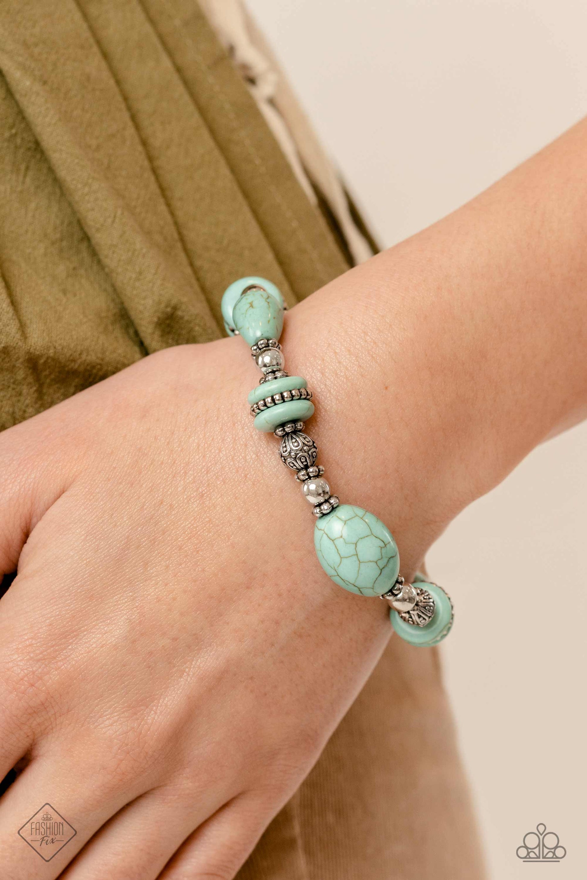 Paparazzi Accessories Changing Cleopatra - Blue Infused along an elastic stretchy band, an Egyptian-esque collection of muted turquoise stones in various sizes, striped silver beads, textured silver beads, floral silver wheel beads, and silver accents wra