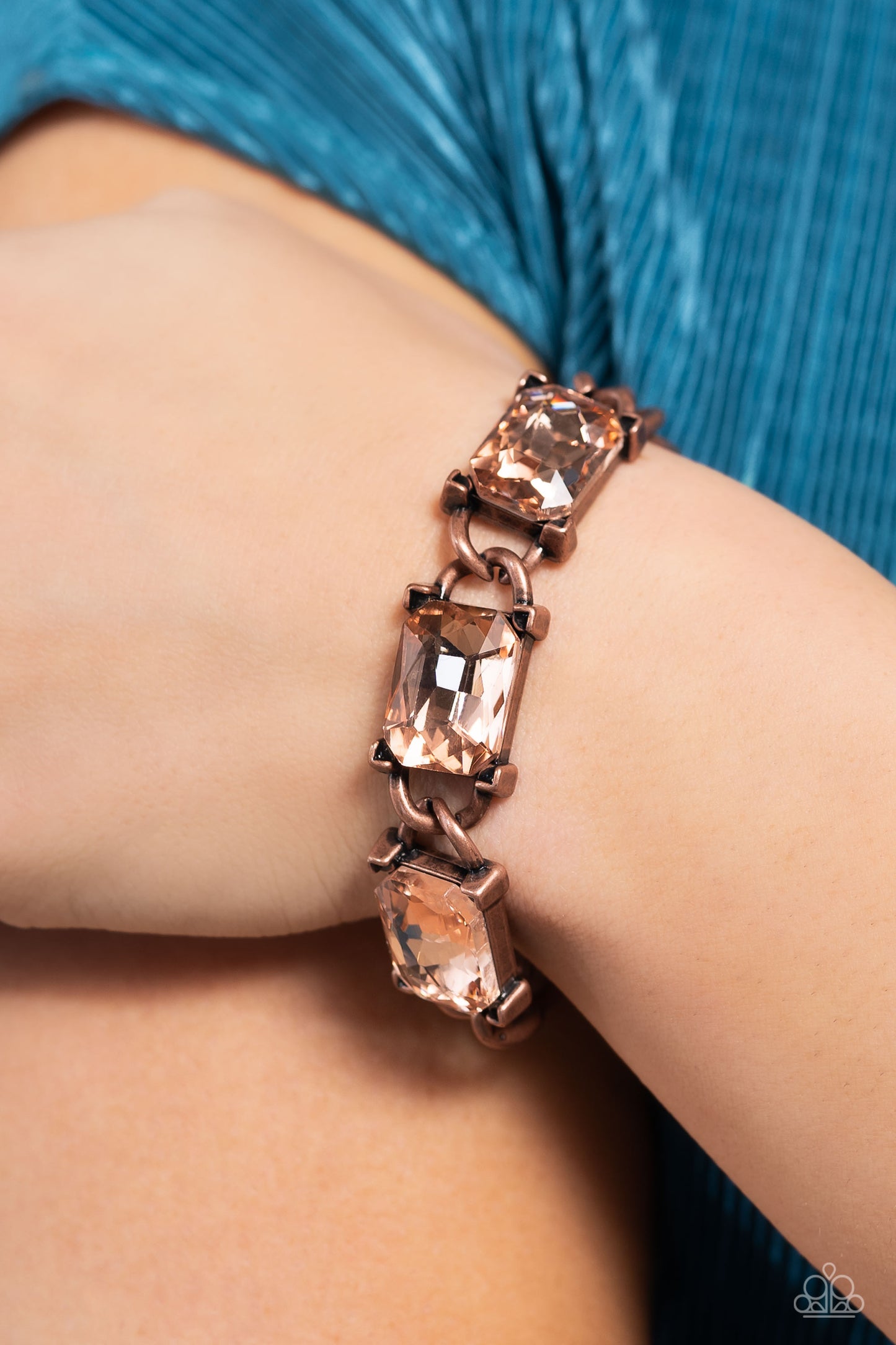 Paparazzi Accessories Dazzling Debut - Copper A trio of gleaming, radiant-cut, peachy gems encased in thick copper frames, wraps boldly around the wrist on a thick copper curb chain for an edgy statement. Features an adjustable clasp closure. Sold as one