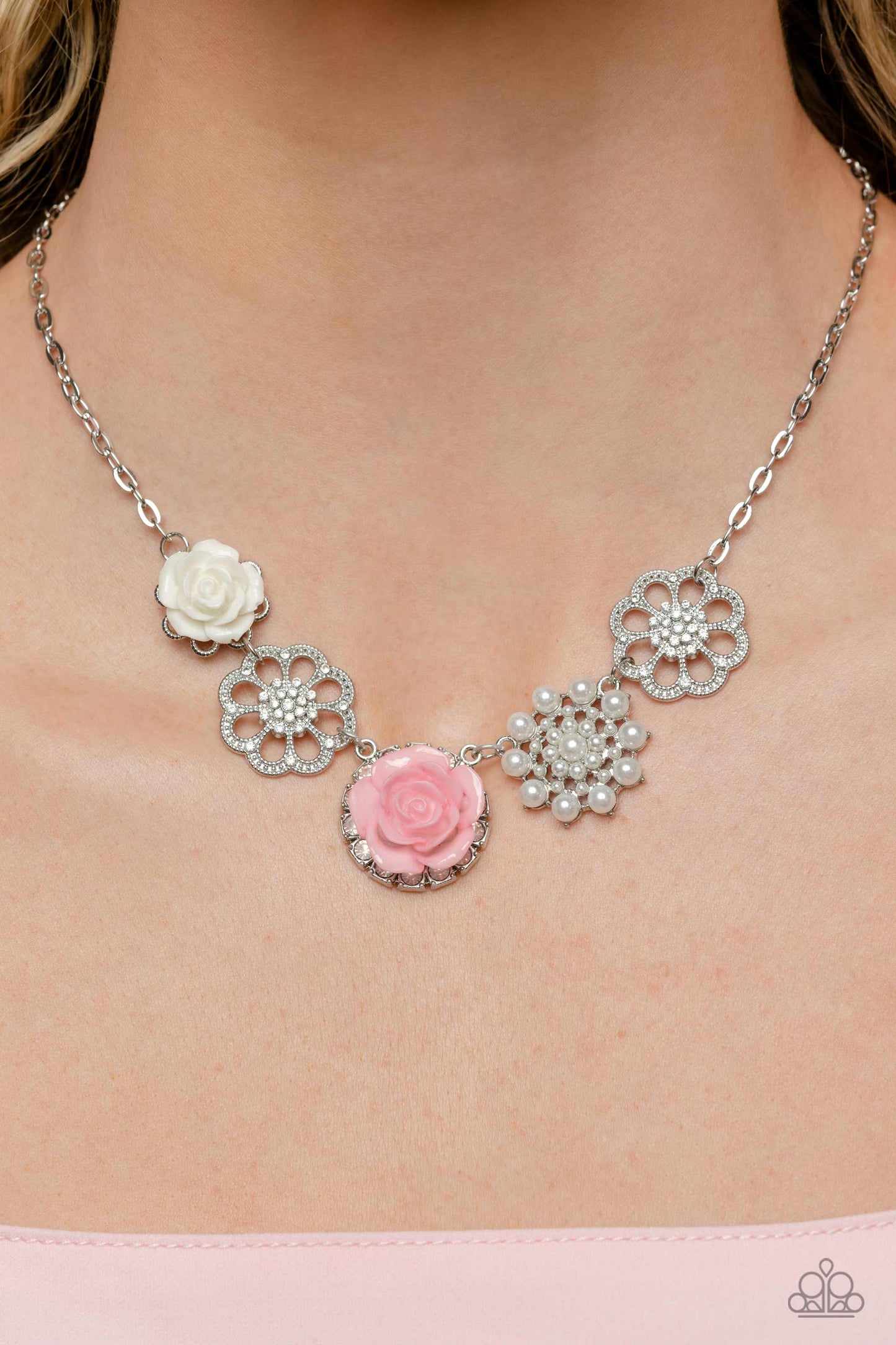 Paparazzi Accessories Tea Party Favors - Pink A collection of whimsical, refined flowers gathers along a flat, sleek silver link chain. The featured charms include an ivory resin rose blooming atop a glittery silver floral silhouette, two silver flowers d