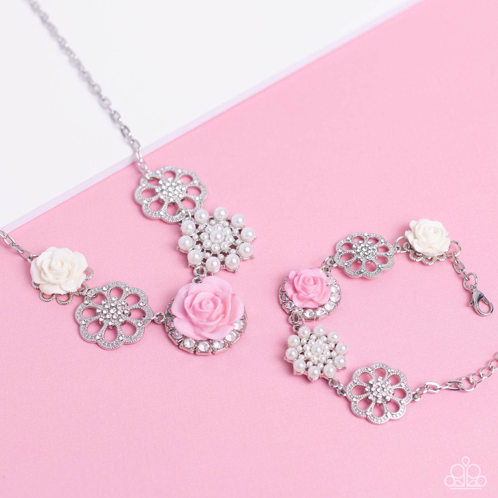 Paparazzi Accessories Tea Party Favors - Pink A collection of whimsical, refined flowers gathers along a flat, sleek silver link chain. The featured charms include an ivory resin rose blooming atop a glittery silver floral silhouette, two silver flowers d