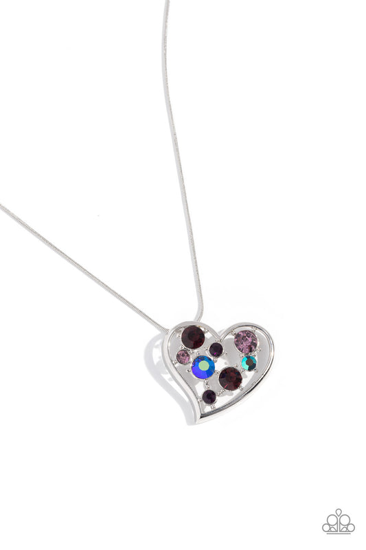 Paparazzi Accessories Romantic Recognition - Purple Cascading from a silver snake chain, a thick, sideways sliding-heart silhouette falls down the neckline for a romantic statement. Haphazardly scattered across the inside of the heart frame, a glittery co