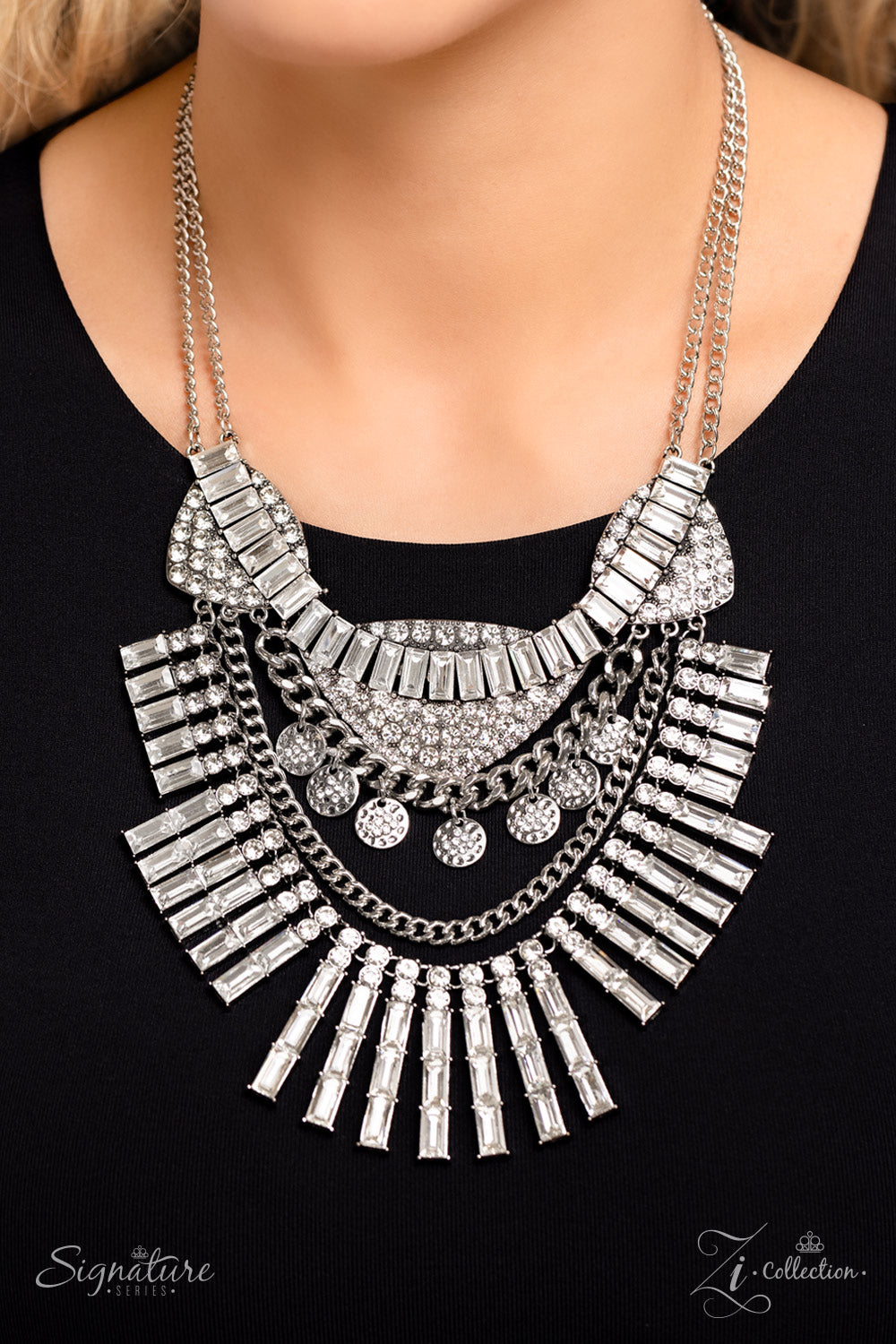 Paparazzi Accessories The Nedra Oversized chain links, silver discs hammered in texture, and a blinding display of brilliant white rhinestones combine to create an iconic statement piece. At the top of the elaborate display, three spade-like pendants fill