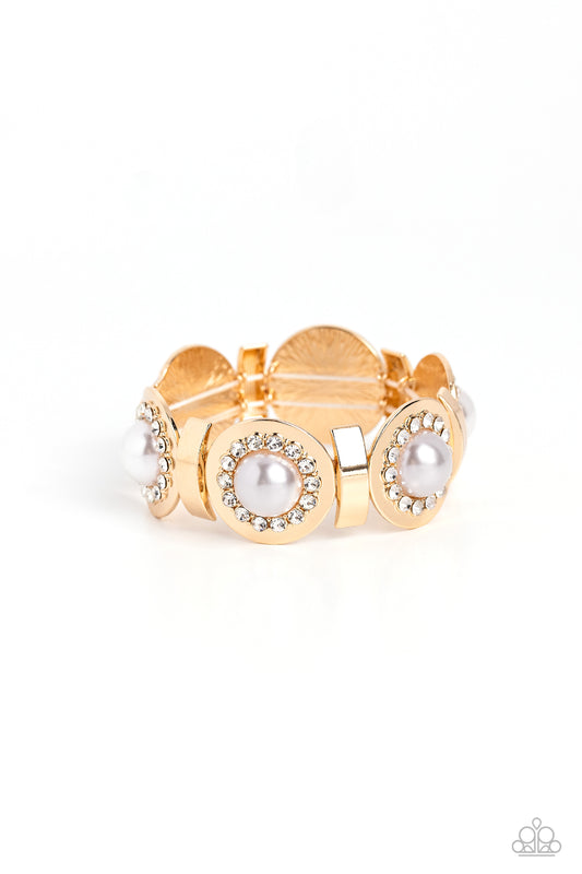 Paparazzi Accessories Summer Serenade - Gold Concaved gold frames, with an embossed row of white gems, encircle an oversized pearl center creating refined flowers. Sleek curls of gold alternate between the bejeweled flowers for additional shine and capric