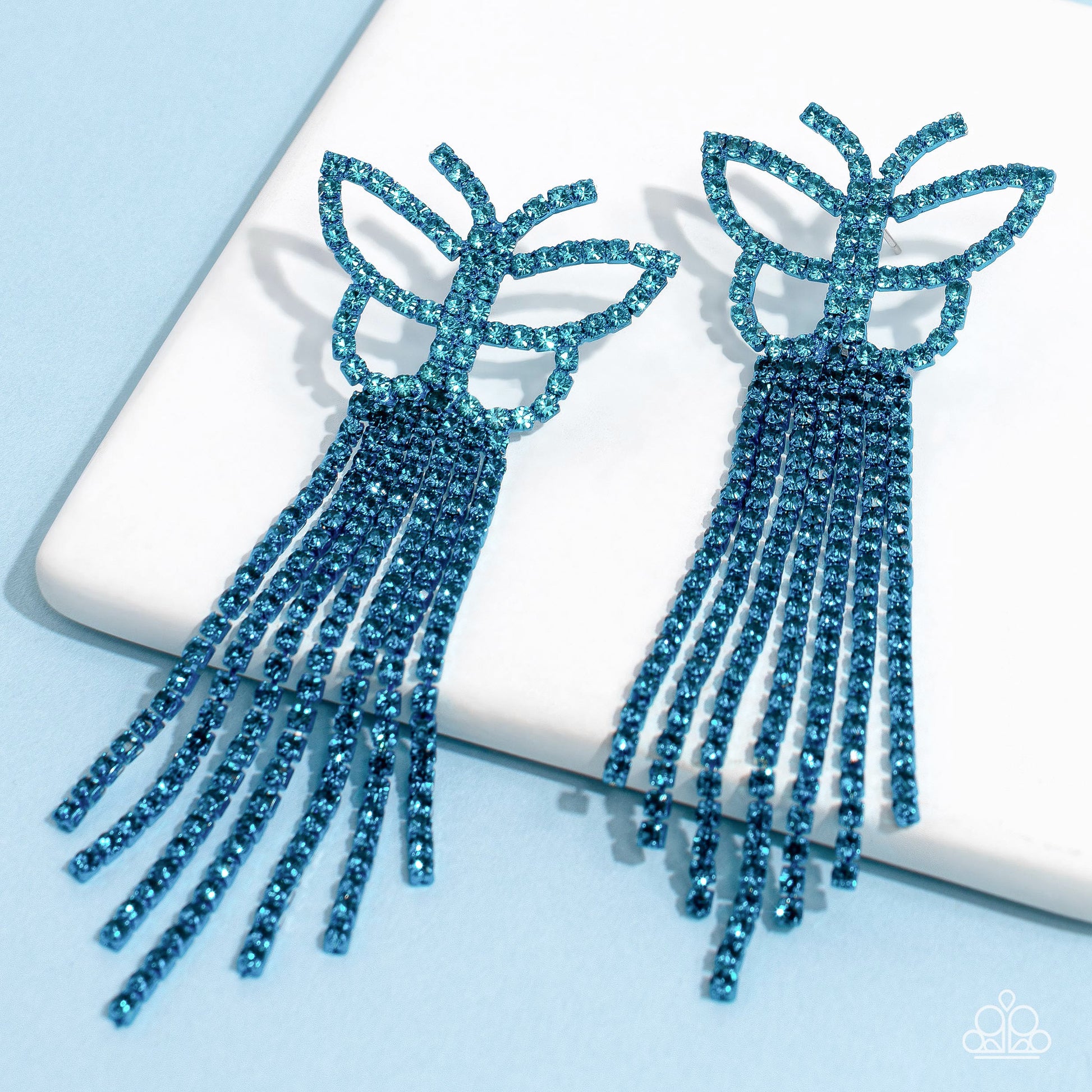 Paparazzi Accessories Billowing Butterflies - Blue Glassy blue rhinestones, encrusted along the front of a blue butterfly frame, create a whimsical centerpiece. Staggered rows of different blue rhinestones pressed in delicate blue square fittings cascade