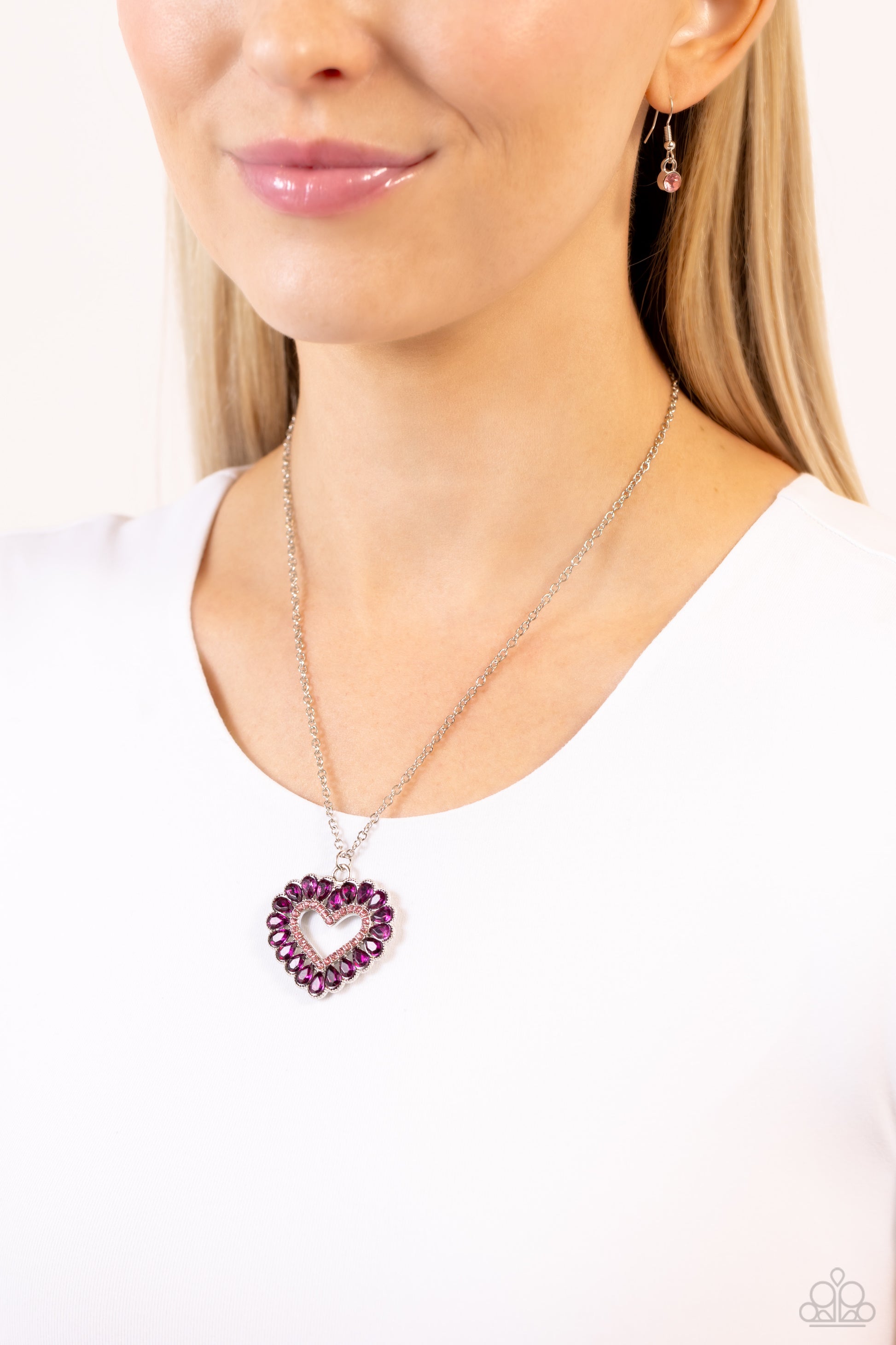 Paparazzi Accessories FLIRT No More - Pink Featuring silver studded frames, fuchsia teardrop gems form into a glitzy heart pendant at the bottom of a dainty silver chain. Light pink rhinestones border the inner heart frame, leaving an airy heart silhouett