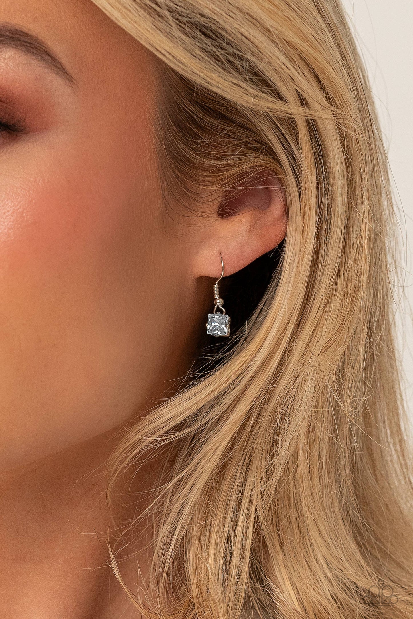 Paparazzi Accessories Lustrous Layers - White Featuring a subtle iridescent finish, exaggerated, faceted round, square, and teardrop gems layer down the chest from three sleek silver dainty chains, in a refined fashion. Features an adjustable clasp closur